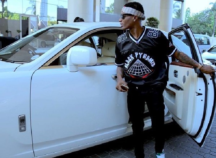 Wizkid posing with Rolls Roys